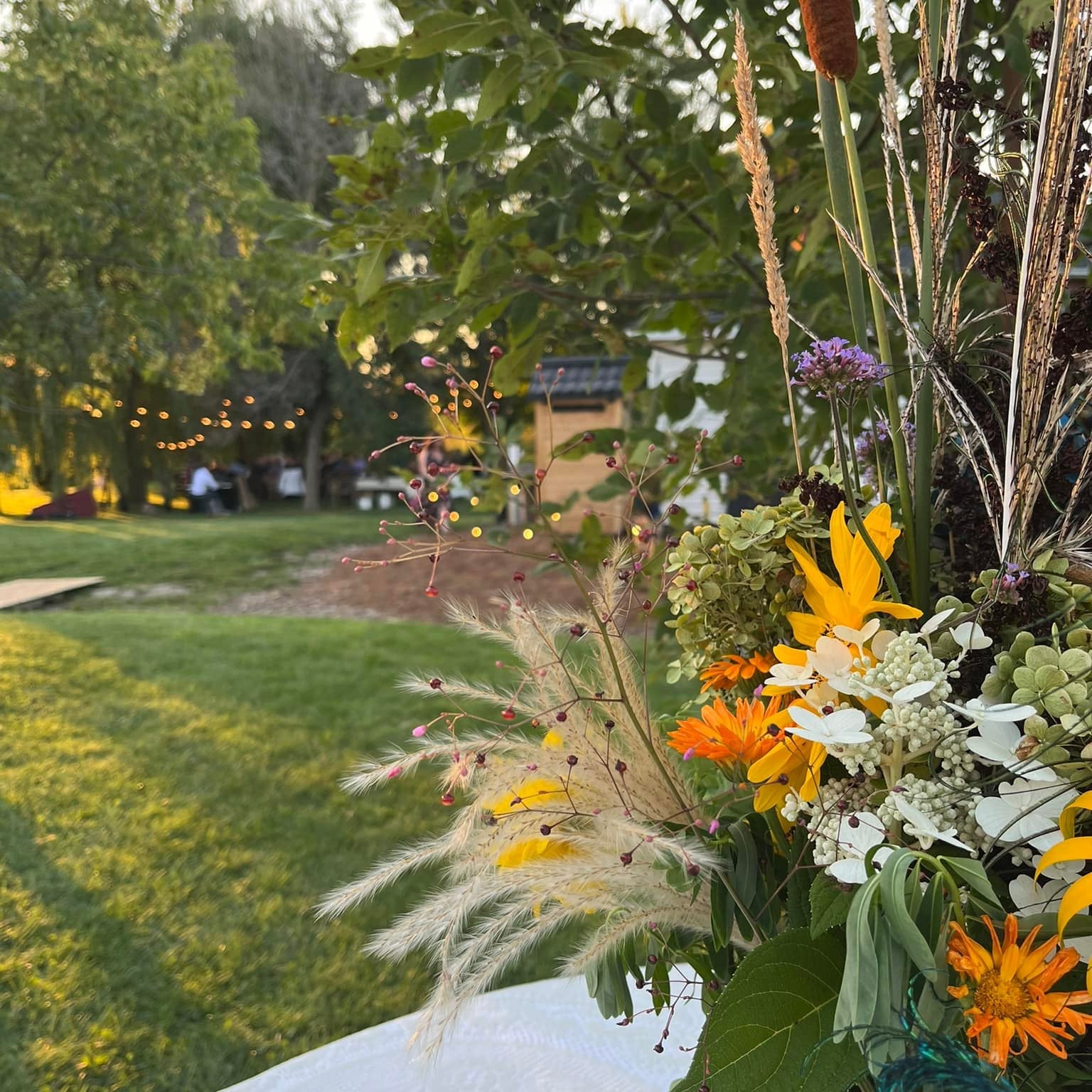 Decorative floral arrangement with cattails and other plants in a park setting