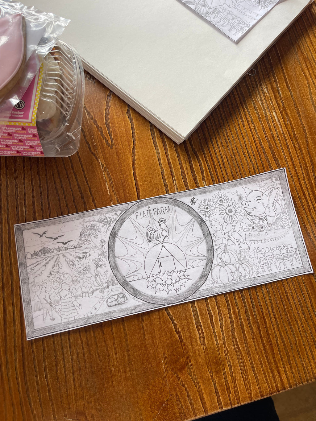 Rectangular metal ruler with engraved design on a wooden surface, goutart community mural