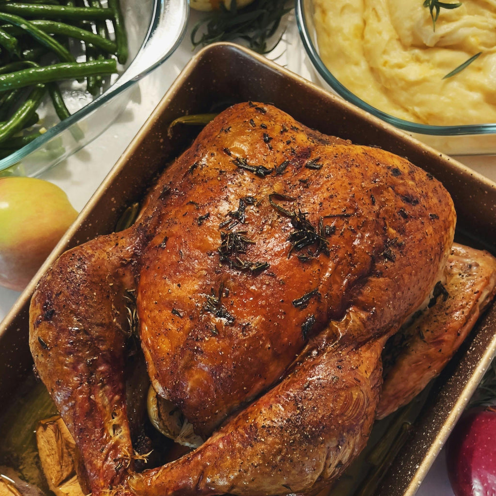 Roasted Chicken on a platter with side dishes including green beans, mashed potatoes, and apples.